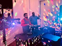 a group of people standing in front of a dj booth