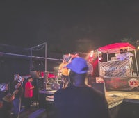 a group of people standing on a stage at night